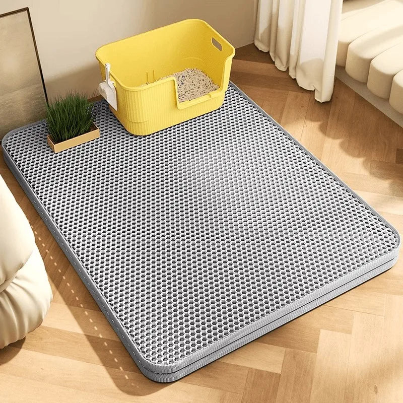 Grey double-layer honeycomb cat litter trapping mat under a yellow litter box